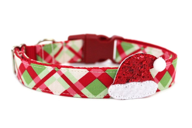 K&ouml;nnte beinhalten: Rotes, gr&uuml;nes und wei&szlig;es karierter Hundehalsband mit einem roten Glitzer-Weihnachtsmann-Hut-Anh&auml;nger.