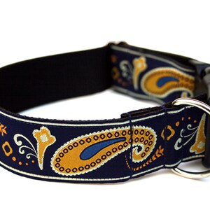 K&ouml;nnte beinhalten: Ein blaues Hundehalsband mit einem Paisley-Muster in Gold und Wei&szlig;. Das Halsband hat eine schwarze Schnalle und einen silbernen D-Ring.