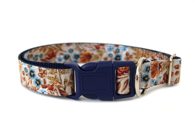 May include: A blue and white floral dog collar with a navy blue buckle and silver D-ring.