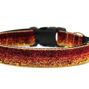 Peut inclure: Un collier de chien rouge, orange et or à paillettes avec une boucle noire.