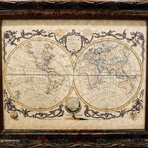 May include: A vintage world map print in a brown wooden frame. The map is in a circular format and shows the continents of North America, South America, Europe, Asia, Africa, and Australia. The map is surrounded by a decorative border with floral motifs.