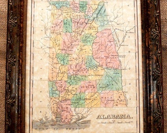 Può includere: Mappa vintage incorniciata dell'Alabama, con una rappresentazione dettagliata delle contee dello stato in vari colori pastello. La mappa è racchiusa in una cornice di legno marrone scuro e ornata, che aggiunge un tocco classico. La mappa include il testo "ALABAMA."