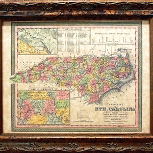 May include: An antique map of North Carolina, printed in color, with a table of distances and a profile of the Dismal Swamp Canal. The map shows the "Gold Region" of the state.
