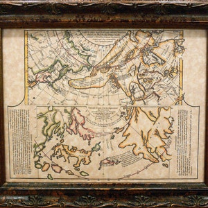 May include: Framed antique map print with a dark brown ornate wooden frame. The map features detailed illustrations and text in a vintage style, with a cream-colored background and colorful accents. The map is divided into two sections.