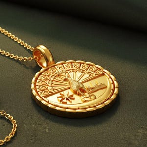 May include: A gold-colored pendant necklace with a detailed, circular pendant. The pendant features a bird, a building, and a starburst design. The necklace chain is also gold-colored, and the pendant is approximately 1.5 inches in diameter.