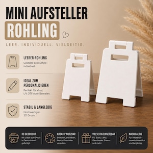Puede incluir: Dos mini soportes de letreros blancos en blanco. Los letreros son de estilo A-frame con una parte superior rectangular y una base inclinada. El texto de la imagen dice "MINI AUFSTELLER ROHLING" y "LEER. INDIVIDUELL. VIELSEITIG."