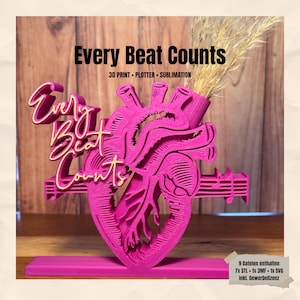 Könnte beinhalten: Eine leuchtend pinkfarbene, 3D-gedruckte herzförmige Vase mit dem Schriftzug "Every Beat Counts" in Schreibschrift. Die Vase enthält getrocknetes Ziergras. Das Design umfasst Noten und eignet sich für die Inneneinrichtung.