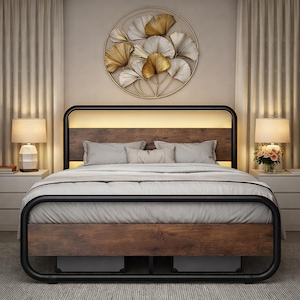 May include: A modern bed frame with a dark wood headboard and footboard, accented by a black metal frame. The headboard features a warm, glowing light. The bed is made up with gray bedding and pillows.