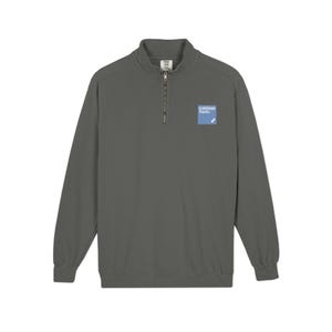 May include: A charcoal gray long-sleeve pullover with a quarter-zip neckline. The shirt features a small, light blue square patch with the text "Goldman Sachs" on the upper right chest. The pullover has a relaxed fit.