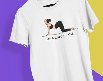 May include: White t-shirt featuring a line drawing of a person in the Child Support Pose yoga position. The person is wearing a black sports bra and leggings. The text "CHILD SUPPORT POSE" is printed below the illustration.