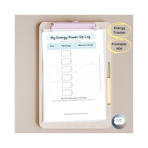 Può includere: Un tracker energetico PDF stampabile su una lavagna di legno. Il registro presenta sezioni per l'ora, i livelli di energia e le attività. Il testo "My Energy Power-Up Log" è in alto. Una penna gialla è appoggiata accanto alla lavagna.