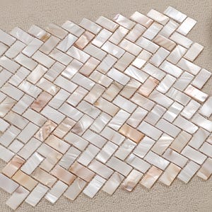 May include: A close-up of a mosaic tile pattern. The tiles are rectangular and arranged in a herringbone pattern. The tiles are primarily white with subtle peach and beige accents, creating a pearlescent effect. The tiles are likely made of mother of pearl.