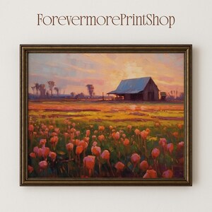 Op de afbeelding: Een ingelijst landschapsschilderij van een schuur bij zonsondergang. Het kunstwerk toont een veld met roze bloemen, een schuur en bomen. De lucht is een mix van oranje en geel. De tekst "ForevermorePrintShop" staat bovenaan.