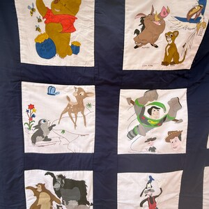 Peut inclure: Une courtepointe faite &agrave; la main avec des personnages Disney. La courtepointe pr&eacute;sente des panneaux avec Winnie l'ourson, Simba, Timon, Pumbaa, Bambi, Buzz l'&Eacute;clair, Baloo et Dingo. Les personnages sont sur fond blanc avec une bordure bleu marine.