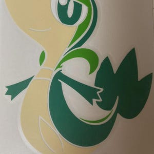 Peut inclure: Un autocollant en vinyle représentant un personnage de dessin animé avec un corps jaune clair et des détails verts. Le personnage a de grands yeux verts, une bouche souriante et une queue verte. Pour la décoration ou la collection.