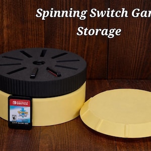 May include: A yellow and black spinning Switch game storage container with a removable lid. A Nintendo Switch game cartridge is placed in front of the container. The text "Spinning Switch Game Storage" is at the top of the image.