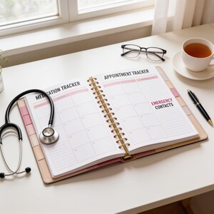 an open appointment tracker notebook on a desk, with a stethoscope, a cup of tea, and a pen nearby.