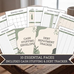 a collection of financial planning and budgeting tools, including a "MONTHLY VIEWS" worksheet, a "SAVINGS TRACKER" worksheet, and a "DEBT REPAYMENT TRACKER" worksheet, all of which are part of a "CASH STUFFING AND DEBT TRACKER" package. The worksheets are arranged on a wooden table, with a mug visible in the background.