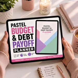 A person is holding a tablet displaying the title "PASTEEL BUDGET & DEBT PAYOFF PLANNER" with a colorful design. The tablet is placed on a table with various items such as a notebook, a mug, and a candle.