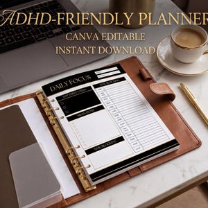 a desk with a laptop, a notebook, a cup of coffee, and a pen. The notebook appears to be a daily focus planner, and the laptop is open, suggesting that the user might be working or studying.