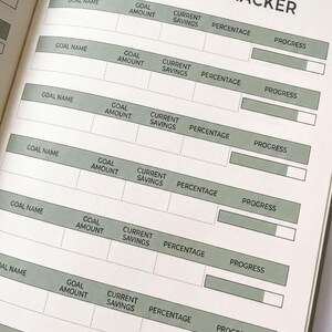 an open notebook with a goal tracking system, displaying a list of goals and their corresponding amounts.