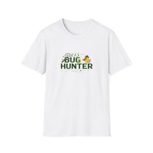 May include: White t-shirt featuring the text "BUG HUNTER" with a magnifying glass, code symbols, and a rubber ducky wearing a hat. The shirt has a crew neck design and is made of a soft material.