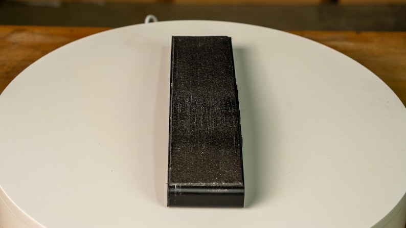 A knife blade being hollow ground on the Bucktool BS242V using the Rayzor Edge radius attachment.