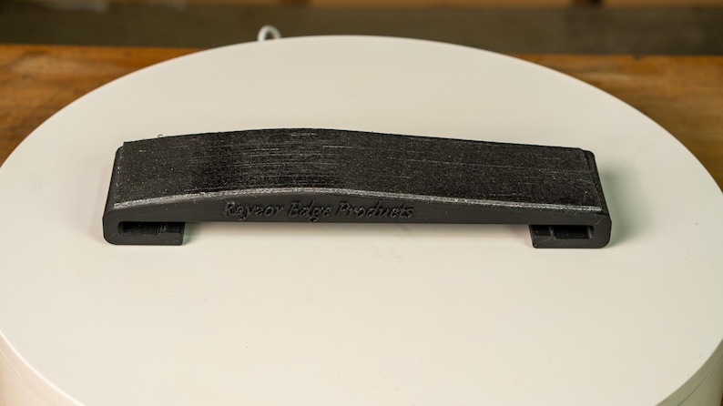 A knife blade being hollow ground on the Bucktool BS242V using the Rayzor Edge radius attachment.