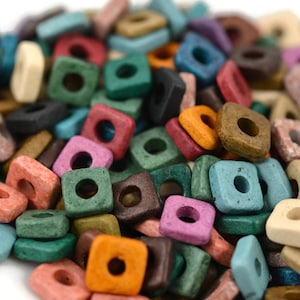May include: A pile of colorful square wooden beads with a hole in the center. The beads are in various colors, including red, green, blue, orange, and brown. These beads are ideal for jewelry making and craft projects.