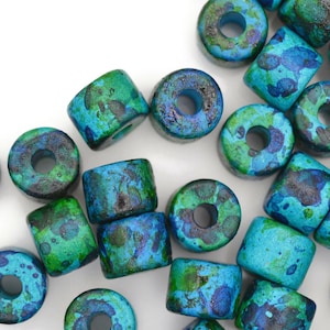 May include: A collection of round wooden beads with a blue and green marbled paint design. The beads have a hole in the center for stringing.