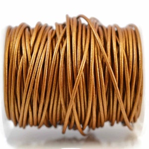 May include: A spool of metallic bronze-colored round cord wrapped in multiple horizontal layers. The cord has a smooth, consistent texture and a reflective finish, wound tightly around a cylindrical core to create a uniform, dense bundle.