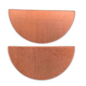 May include: Two copper-colored, half-circle shaped metal components. The components have a brushed texture and a warm, reddish-brown hue. They are displayed against a white background, highlighting their shape and color. These components could be used for jewelry making or other craft projects.