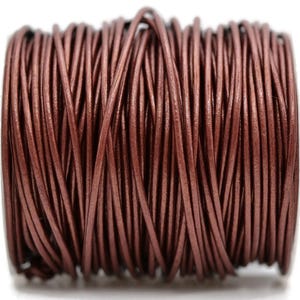May include: A spool of brown leather cord. The cord is tightly wound, showing a multitude of thin, parallel strands. The color is a rich, warm brown, with a slight sheen. This cord is suitable for jewelry making and crafts.
