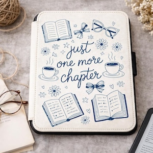 May include: Cream-colored e-reader case with a black border, featuring a blue doodle design. The design includes open books, flowers, bows, glasses, coffee cups, and the phrase "just one more chapter."