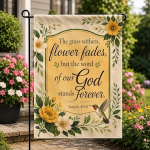 Könnte beinhalten: Eine rechteckige Gartenflagge mit cremefarbenem Hintergrund und gelbem Mittelfeld. Der Text lautet: The grass withers, flower fades, but the word of our God stands forever. Isaiah 40:8. Sie ist mit gelben Blumen und einem Kolibri verziert.