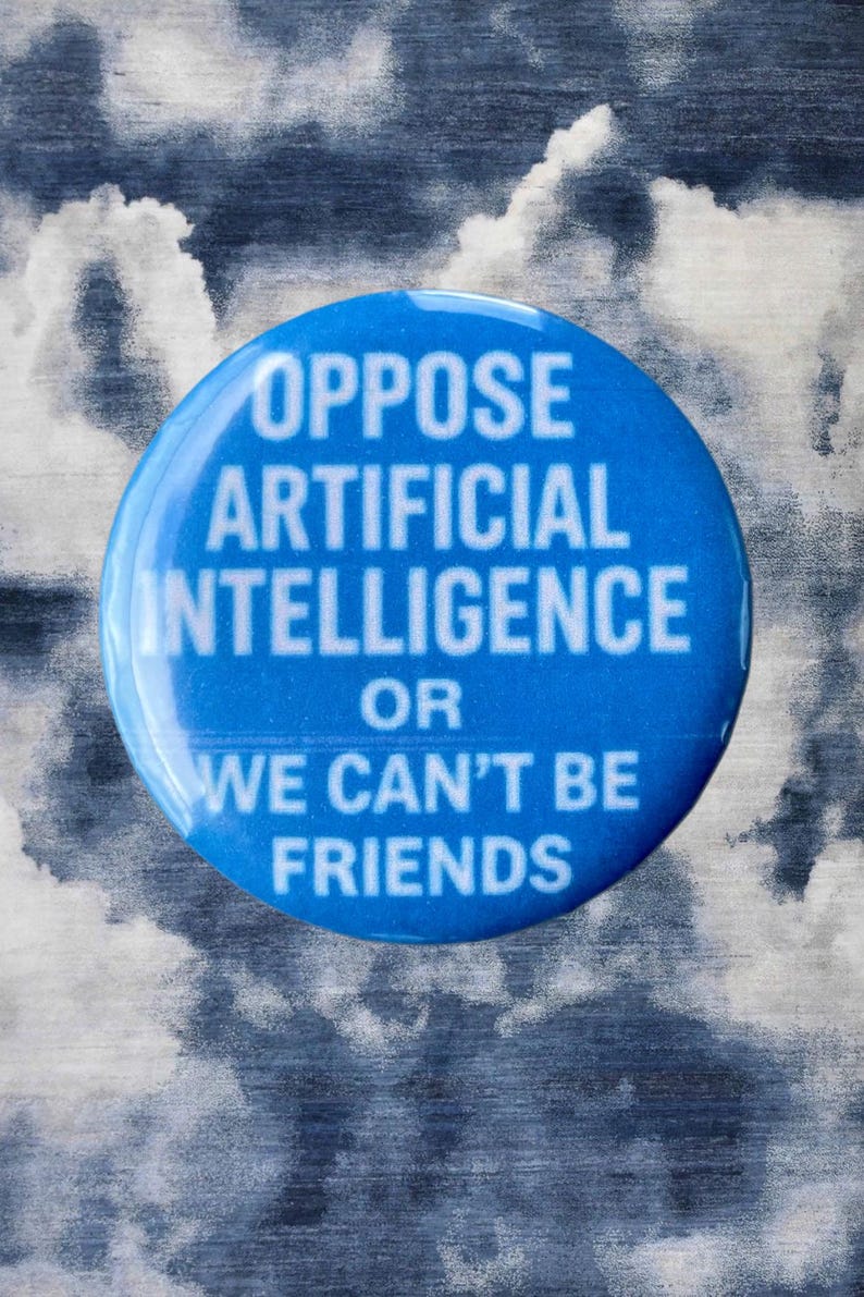 Pode incluir: Um bot&atilde;o redondo azul com texto branco: "OPPOSE ARTIFICIAL INTELLIGENCE OR WE CAN'T BE FRIENDS." O bot&atilde;o est&aacute; sobre um fundo texturizado com nuvens cinzentas e brancas.