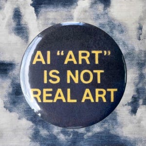 Pode incluir: Um bot&atilde;o preto com o texto "AI 'ART' IS NOT REAL ART" em amarelo. O bot&atilde;o est&aacute; sobre um fundo de um padr&atilde;o de nuvens azuis e brancas.
