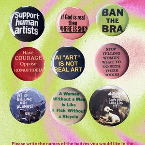 K&ouml;nnte beinhalten: Eine Sammlung von neun runden Ansteckbuttons mit verschiedenen textbasierten Slogans und Grafiken. Die Buttons enthalten Phrasen wie Support human artists, If God is real then WHERE IS SHE?, BAN THE BRA, AI ART IS NOT REAL ART und weitere.