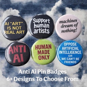 Könnte beinhalten: Eine Sammlung von sechs runden Anstecknadeln mit Anti-KI-Botschaften. Die Anstecknadeln zeigen Texte wie "AI 'ART' IS NOT REAL ART" und "Support human artists" in verschiedenen Farben. Der Hintergrund ist ein bewölkter Himmel.