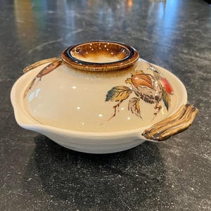 May include: A white ceramic mug with a black handle and the text "But First, Coffee" in a black, bold font. The mug is on a white surface.