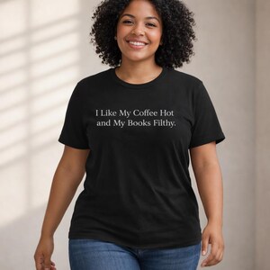 May include: Black crew neck t-shirt with the text "I Like My Coffee Hot and My Books Filthy" in white. The shirt is made of a soft material and is suitable for casual wear.