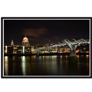 Puede incluir: Paisaje urbano nocturno con un puente y un edificio con cúpula, probablemente una catedral, iluminados. El agua refleja las luces de la ciudad, creando un efecto brillante. El cielo es oscuro con algunas nubes.