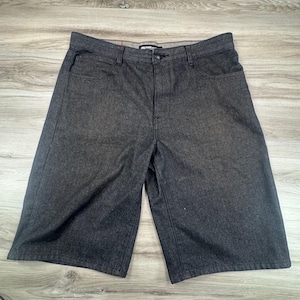 May include: Dark charcoal gray denim shorts featuring a classic five-pocket design, a button and zipper fly closure, and a waistband with belt loops. The shorts have a straight-leg cut and visible tonal stitching throughout the fabric construction.
