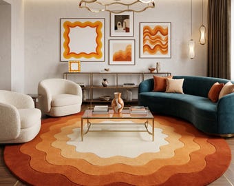 May include: A living room with a retro design featuring a large, round rug with wavy layers of orange and cream colors. The room includes a teal sofa, cream-colored armchairs, and framed artwork in orange and white tones. A gold coffee table and a decorative light fixture complete the space.
