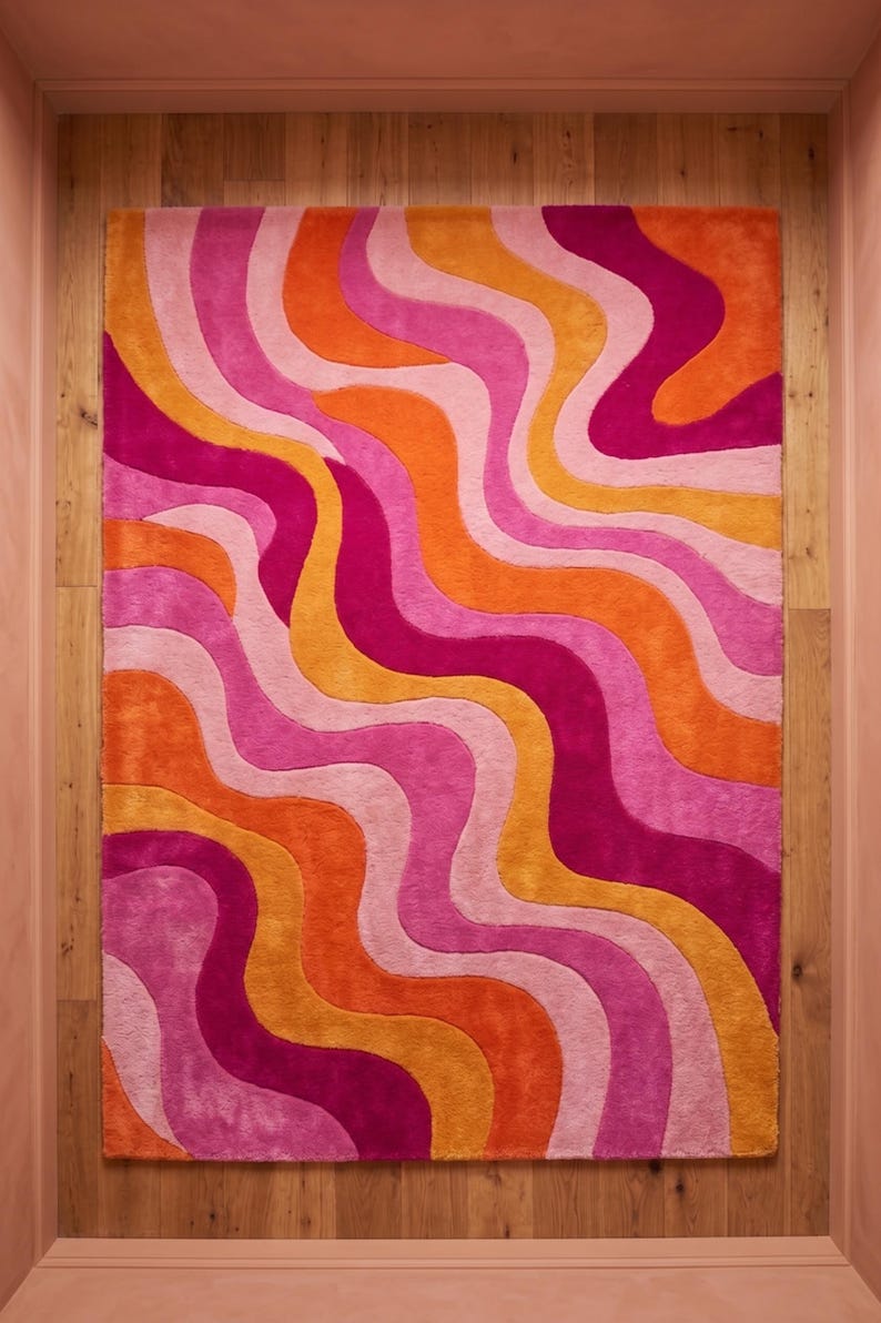 May include: A rectangular area rug featuring a repeating pattern of vertical wavy lines in vibrant shades of hot pink, bright orange, light pink, and golden yellow. The rug has a plush, textured surface with distinct color-blocked sections.