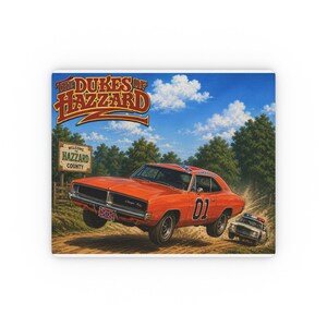 May include: A rectangular print featuring an orange muscle car with the number 01 on the side, jumping on a dirt road. A police car follows behind. A sign reads Welcome to Hazzard County. The text The Dukes of Hazzard appears at the top.