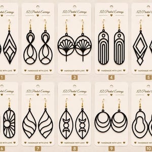 May include: Ten pairs of black 3D printed earrings displayed on individual white cards labeled 3D Printed Earrings and Handmade with Love. Each pair features unique geometric, floral, or abstract cut-out designs with gold-toned metal hooks.