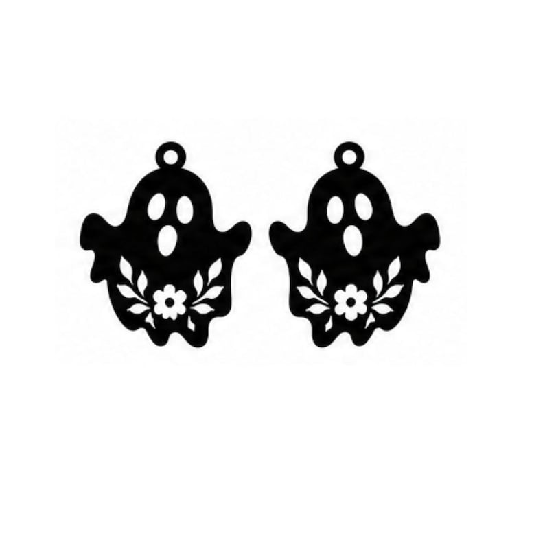 Op de afbeelding: Een paar zwarte spookvormige hangers met een uitgesneden ontwerp van twee ogen, een ovale mond en een centrale bloem omringd door bladeren. Elke hanger heeft een kleine ronde lus aan de bovenkant voor bevestiging, wat een symmetrische set vormt.