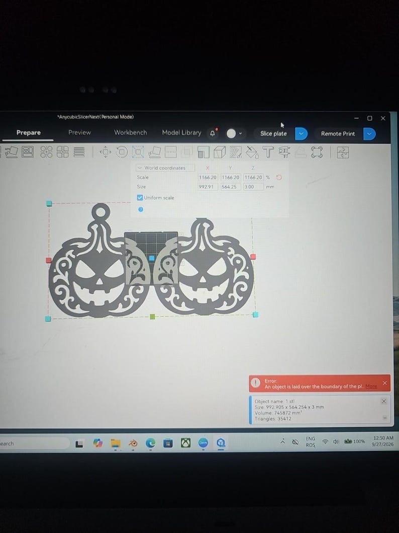 Op de afbeelding: Een computerscherm met de AnycubicSlicerNext software-interface met twee identieke grijze pompoenvormige ontwerpen. De software toont een rode foutmelding die aangeeft dat een object buiten de rand van de printplaat ligt.