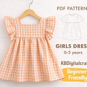 Puede incluir: Un patrón de vestido de niña a cuadros melocotón y blanco, con mangas con volantes, colgado de una percha de madera. El texto en la imagen dice "PDF Pattern", "GIRLS DRESS 0-3 years", "KBDigitalcraft" y "Beginner Friendly".
